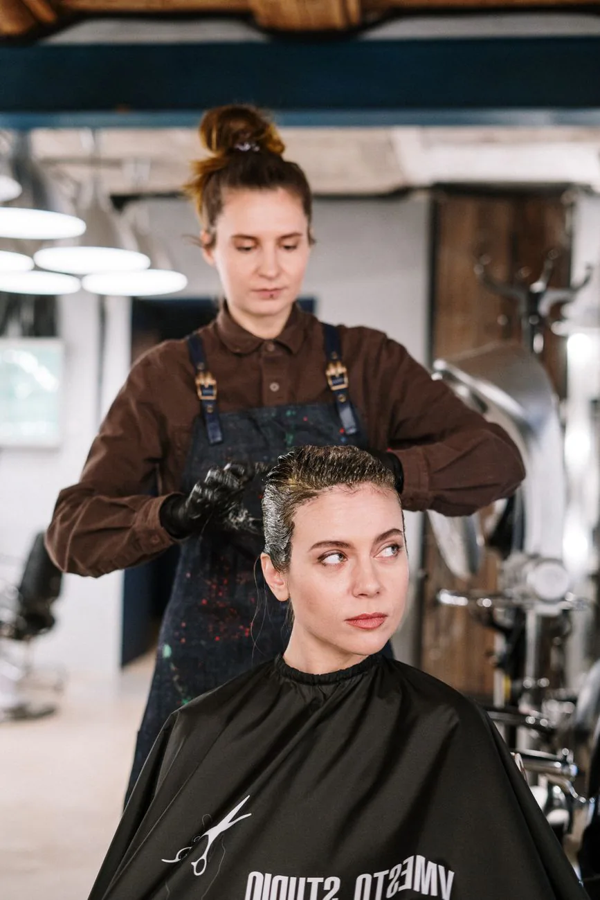 Stylist carefully styling a client's hair in the salon