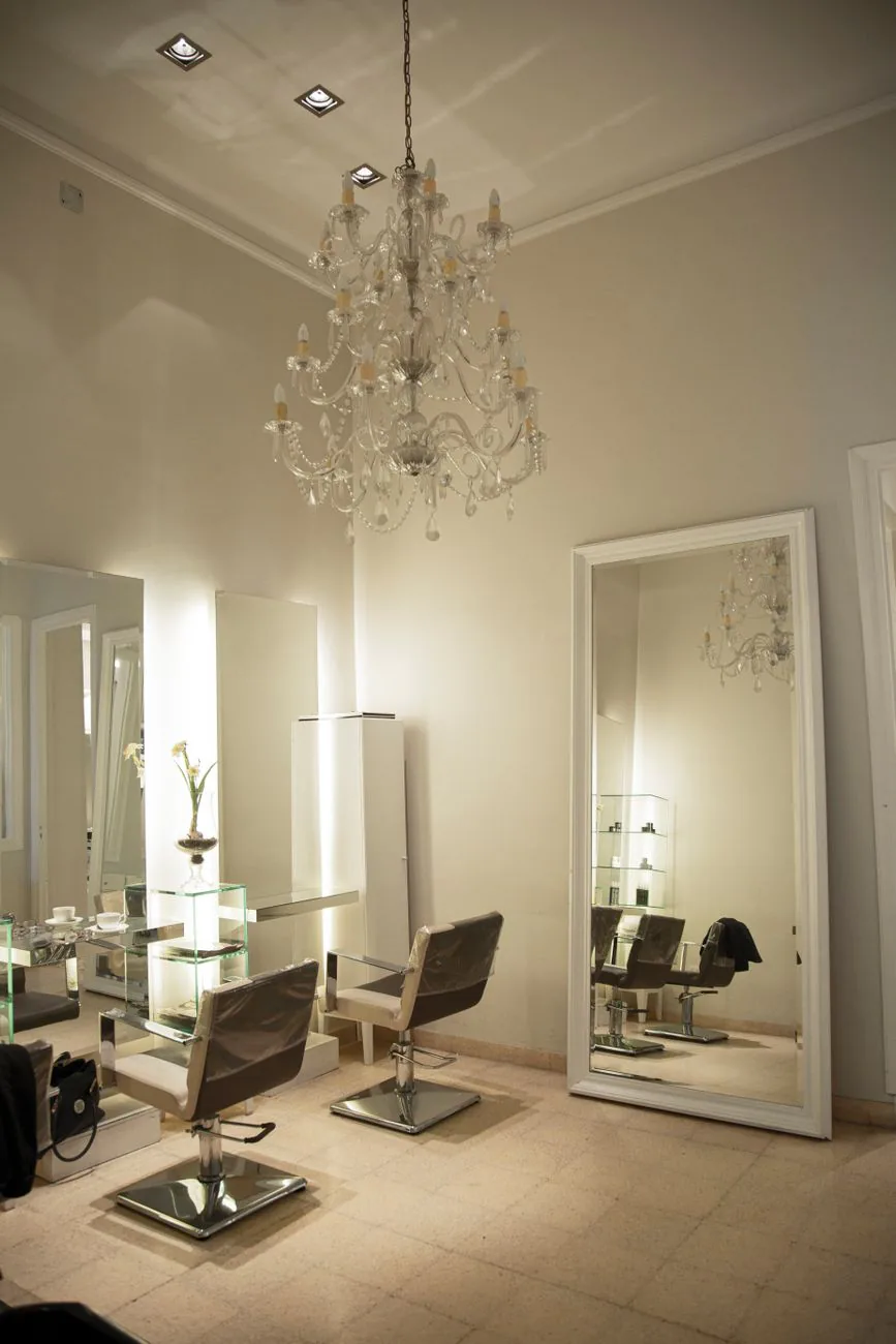 Salon interior with ornate chandelier and large mirrors in a warm setting