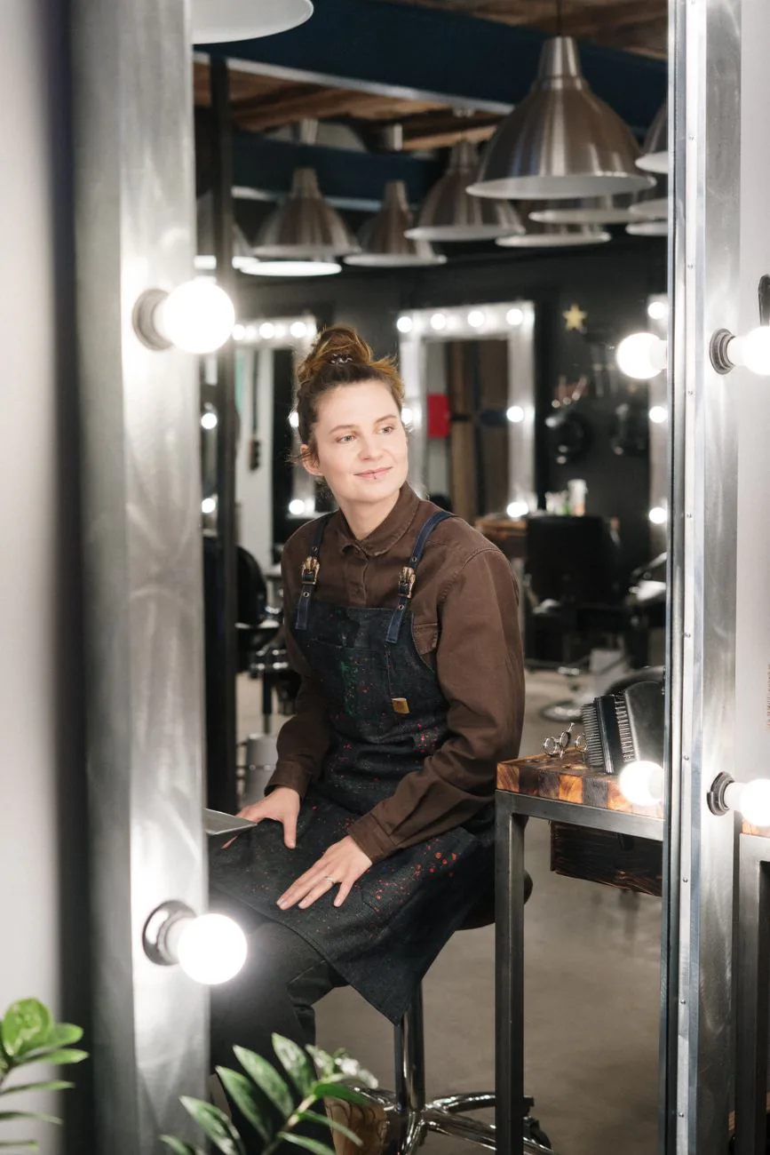 Bianca Reyes, senior stylist, smiling in a chic well-lit salon