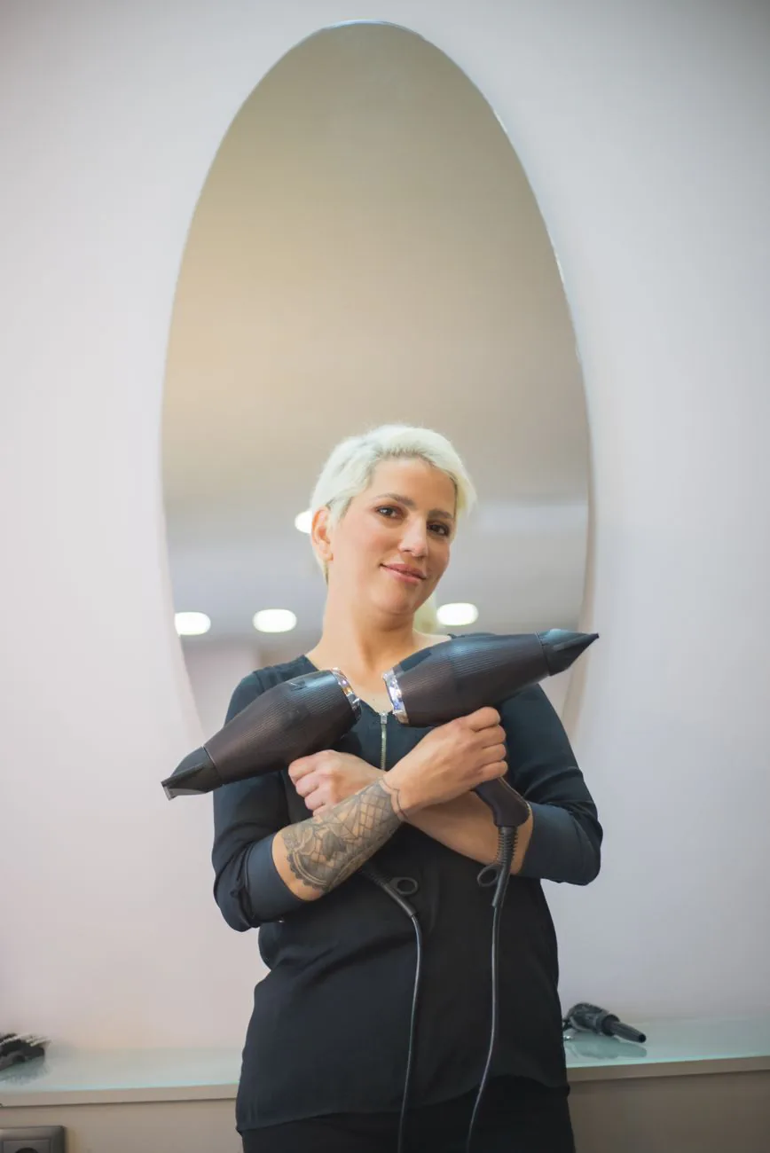 Amelia Durant, color and extensions specialist, confident in front of salon mirror