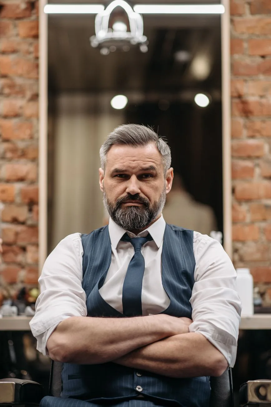 Marcus Cole, men's grooming specialist, posing in a trendy barbershop interior